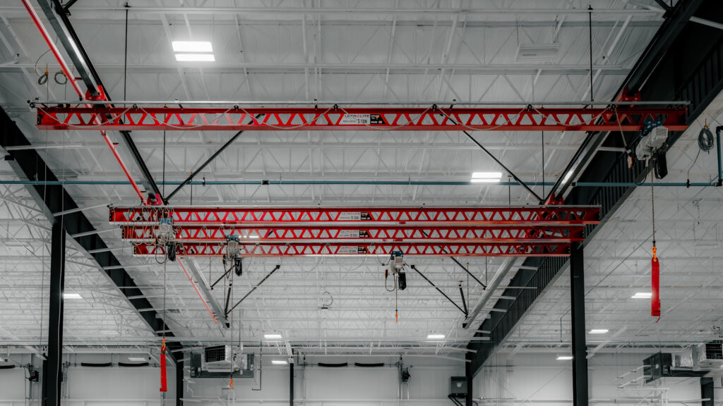 pwi four 1 ton ultralite ceiling mounted bridge crane in manufacturing setting