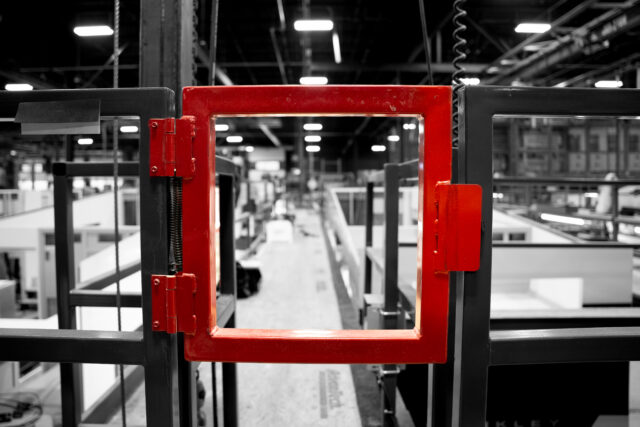 structural space mezzanine closed manual swing gate in manufacturing setting