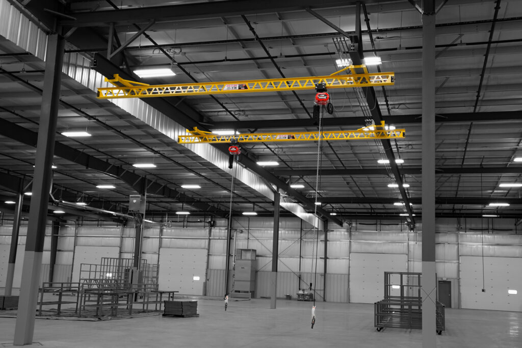 two 1 ton pwi ceiling mounted ultra lite cranes cm lodestar hoists in manufacturing setting